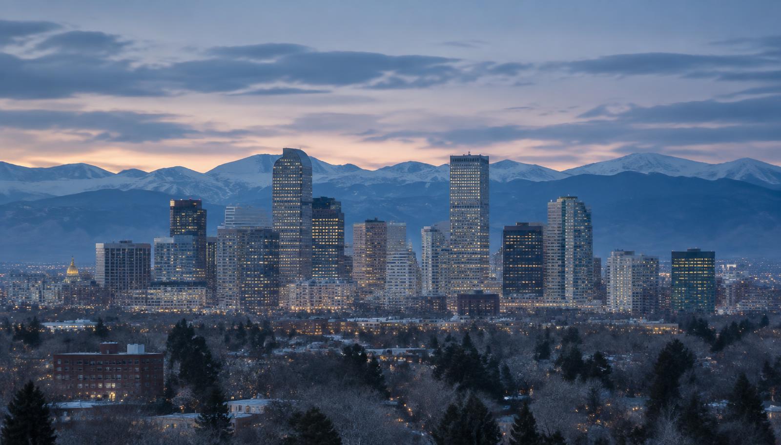 Denver skyline at dusk with the Front Range behind it